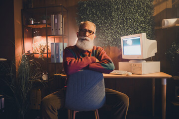 Mature programmer working in a home office with vintage computer technology, surrounded by cozy...