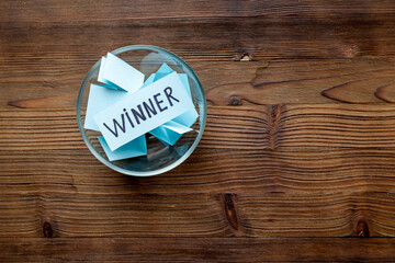 Glass jar full of folded paper sheets with raffle ticket winner