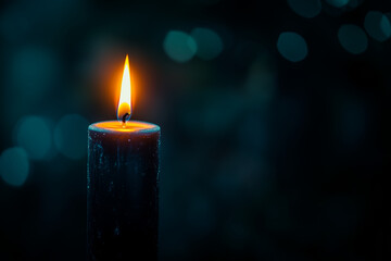 single, long candle burning with a small flame, surrounded by darkness