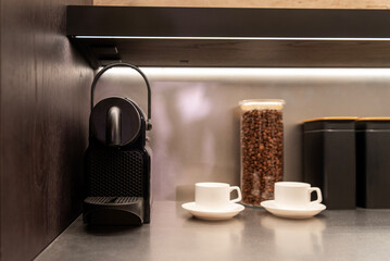 Capsule coffee machine with cups and jar of roasted beans