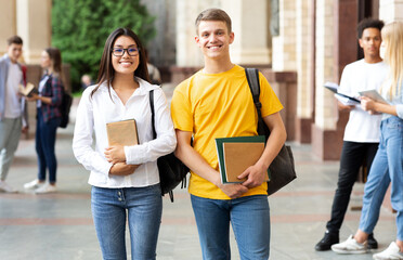 Happy diverse students having break in university campus, smiling to camera