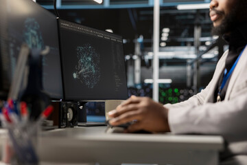 Close up of programmer in data center using AI powered tech to run simulations. IT expert coding...