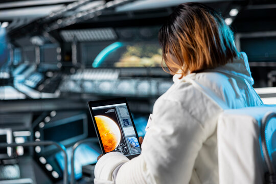 Astronaut checks tablet before landing spaceship powered by advanced engineering on Mars. Crew preparing for mission launch to red planet surface, testing future human survival in deep space