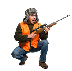 Naklejka premium A hunter in a fur hat and orange safety vest crouches with a rifle, showing a surprised expression. PNG on transparent background.