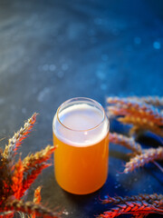 Craft draft beer on blue table with wheat ears and copy space
