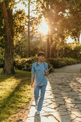 Healthcare professional walking through sunlit park - obrazy, fototapety, plakaty