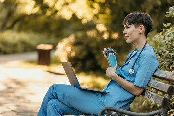 Medical professional relaxing outdoors with laptop