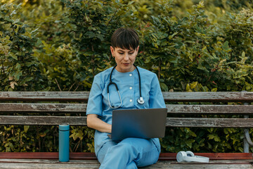 Fototapeta premium Medical professional working on laptop outdoors