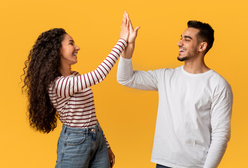 Portrait Of Happy Young Arab Couple Giving High Five To Each Other, Cheerful Middle Eastern Man And...