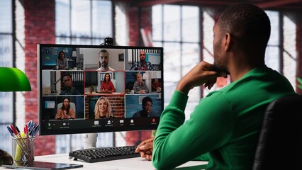 Manager talking to employees during web video call at home, analyzing business documents,...