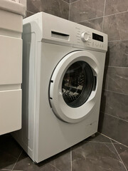 Washing machine in bathroom or in kitchen, necessary appliance in house that facilitates washing process, used in laundry, hospital, hotel, kindergarten, sanatorium, dry cleaners