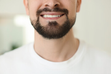Smiling man before shaving on blurred background, closeup