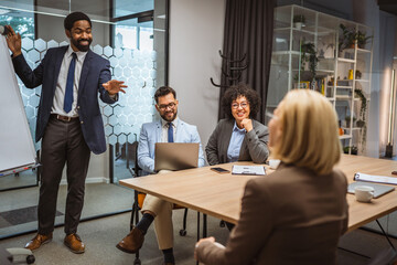 Man tutor present project on whiteboard to diverse colleagues
