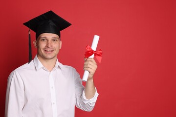 Happy student with diploma after graduation on red background. Space for text