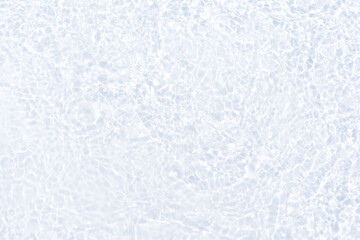 White water with ripples on the surface. Defocus blurred transparent white colored clear calm water surface texture with splashes and bubbles. Water waves with shining pattern texture background.