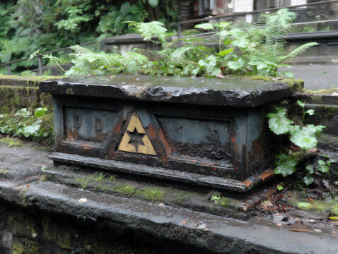 close-up photograph of a cryptic symbol or marking carved into an old stone wall