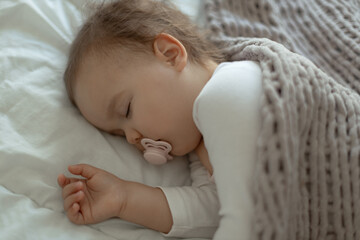 Infant baby sleeping peacefully with pacifier