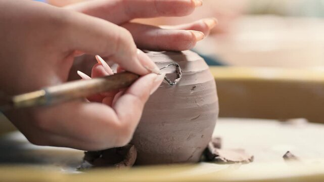 Potter refining clay with tool