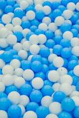 Colorful blue and white balls scattered on a play area floor, perfect for children's activities and fun playtime moments