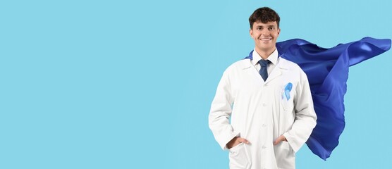 Male doctor in superhero cape and with blue ribbon on color background with space for text....