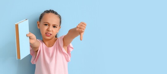 Little girl with book showing dislike on blue background with space for text