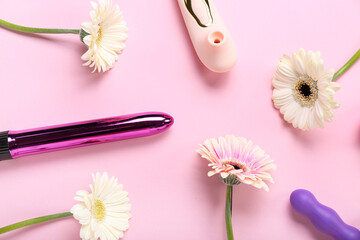 Vibrators with gerbera flowers on pink background