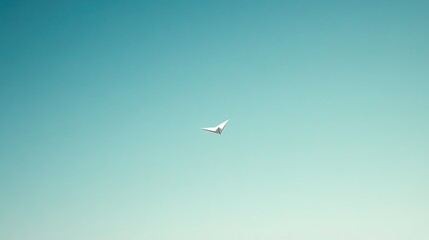 Fototapeta premium A single paper airplane flying through a clear blue sky