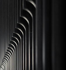 Black wooden louvres inside a dark room creating a black and white striped background.