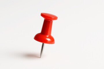 Single, glossy red push pin or thumbtack, sharply focused and casting a subtle shadow, isolated on a pristine white background, symbolizing marking, planning, or a reminder.