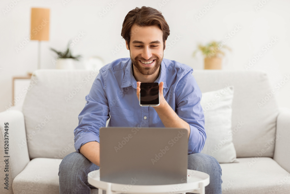 Poster cheerful guy using voice assistant on mobile phone or talking using loudspeaker mode on smartphone s