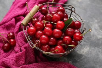 Basket with fresh cherry on grey background, closeup