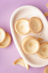 Bowl with homemade tartlets on lilac background