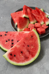 Plate with pieces of fresh watermelon on grey background