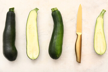 Fresh green zucchini with knife on white background