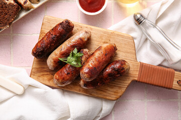 Wooden board of tasty grilled sausages on pink tile background