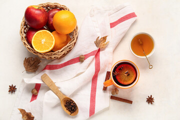 Cup of hot mulled wine with orange and bowl of honey on white background