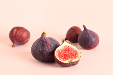 Fresh juicy cut figs on pale pink background
