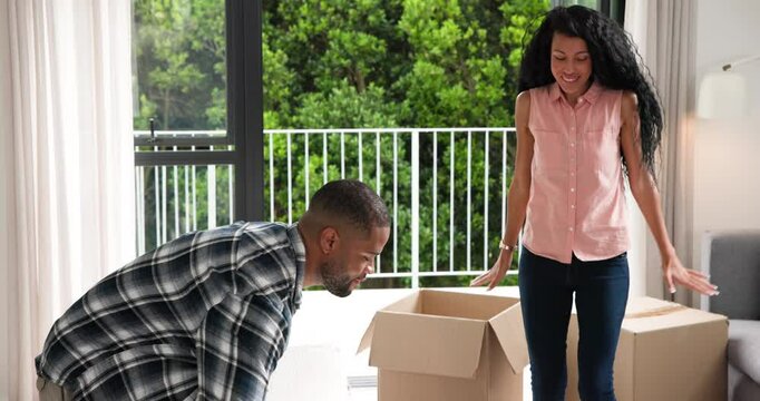 African American couple unfolding boxes, placing plant and chair near sliding doors during move-in