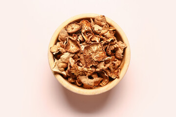 Wooden bowl with tasty dried mushrooms on pink background
