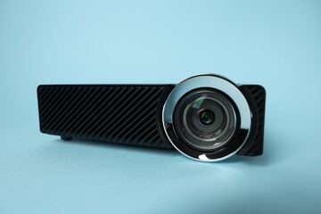 Modern video projector on light blue background, closeup
