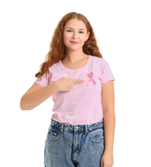 Fototapeta premium Young redhead woman pointing at awareness pink ribbon on white background. Breast cancer concept
