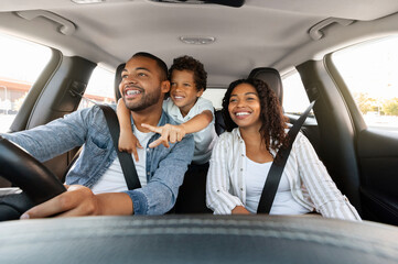 Beautiful cheerful loving african american family enjoying car trip. Cute preteen black boy...