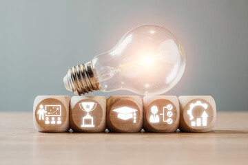 Light bulb and icons on wooden blocks symbolize upskilling, learning, and innovation in a modern...