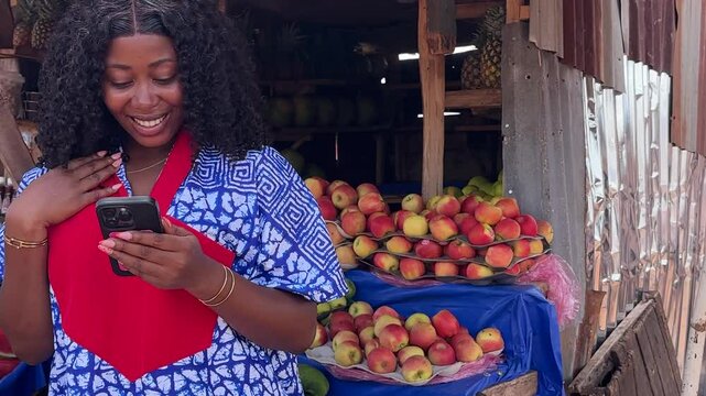 woman isolated over business fruit stand shocked receiving phone notification