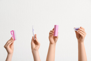 Female hands holding cuticle oil pen with brush, buffer and sea salt on white background