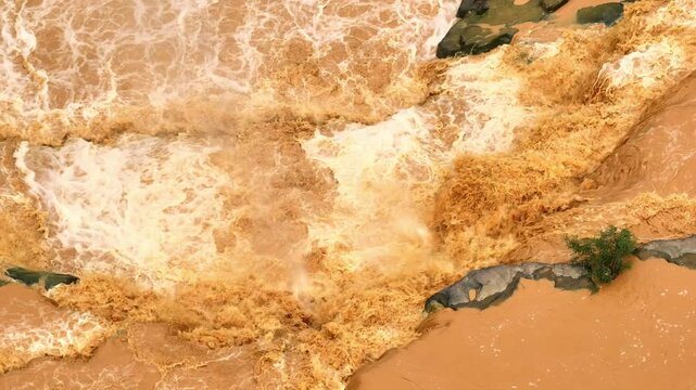 Drone captures muddy waters surging rapidly, highlighting the combined effects of heavy rainfall and deforestation in destabilizing soil and increasing flood hazards.
