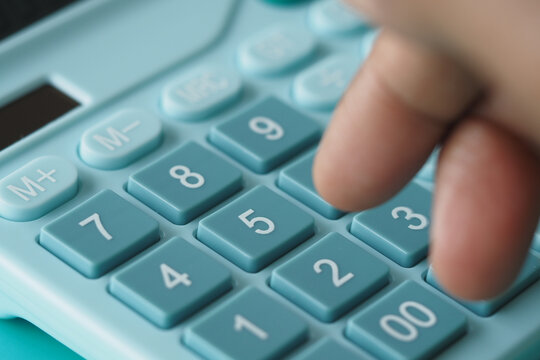 Pressing buttons on a teal calculator