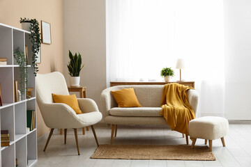 Interior of living room with comfortable sofa, armchair, bookcase and yellow plaid