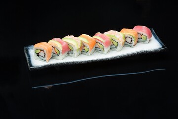 rainbow california avocado inside-out sushi roll ont the plate
