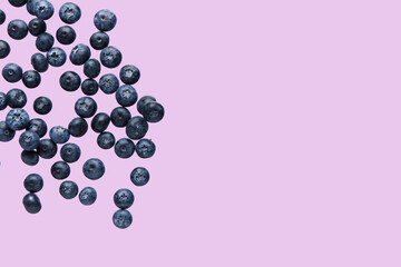 Flying sweet fresh blueberries on lilac background
